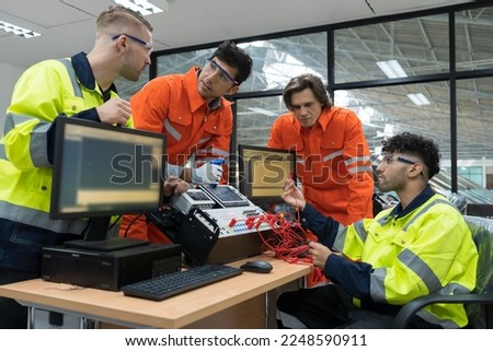 Team male engineers discuss and using desktop computer training Programmable logic controller or Programmable controller in the manufacturing automation and robotics academy room