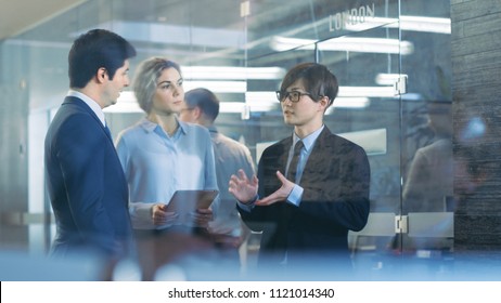 Team Of Male And Female Diplomats Talking With Asian Businessman, Establishing Business Contacts And International Relations. High Class Corporate Building.