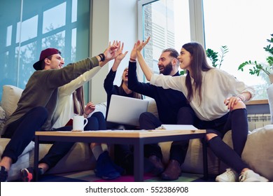 Team of male and female freelancers celebration finishing work on creation successful startup strategy using digital devices and internet connection giving high five and feeling exciting in workshop - Powered by Shutterstock