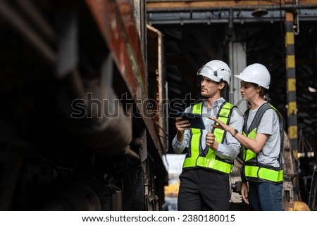 Team male and female using tablet railway technician engineer Inspect repair service project train diesel engine in maintenance center. Transportation railway concept.