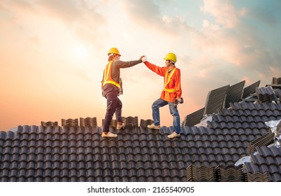 A Team Of Male Roofers Uses A Cordless Electric Battery Drill To Fire Screws To Install Concrete Roofing Slabs Or C-packs On Home Structure Construction They Happy After Work Success