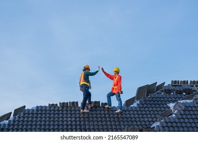 A Team Of Male Roofers Uses A Cordless Electric Battery Drill To Fire Screws To Install Concrete Roofing Slabs Or C-packs On Home Structure Construction They Happy After Work Success