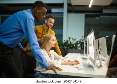 Team of managers looks on screen in IT office - Shutterstock ID 2042454149