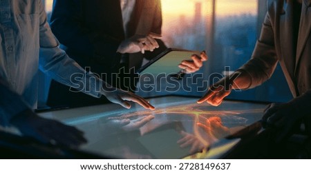 A team of managers working in the office. Hands and a touch screen in close-up