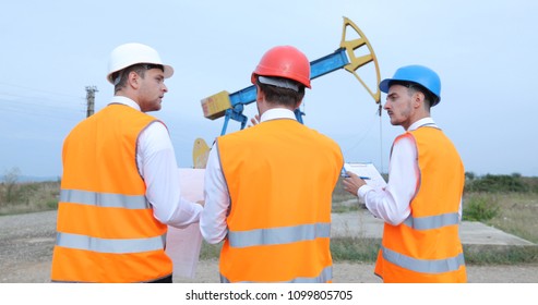 Team of Master Engineers Men Walking and Discussing about Global Gas Volume in Petrochemical Oil Pump Field