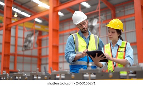 Team of mechanical engineer inspecting machines and robotic system in manufacturing factory. Engineers discussing together while inspect in factory. - Powered by Shutterstock