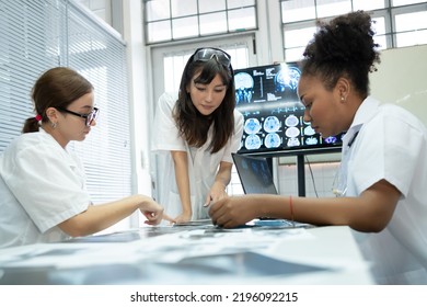 Team of medical doctor meeting in the brain research laboratory by monitor showing MRI, CT scans brain images. Group of female doctor discussing surgery and treatment with medical x-ray scan papers - Powered by Shutterstock