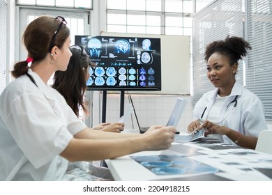 Team of medical doctor meeting in the brain research laboratory by monitor showing MRI, CT scans brain images. Group of female doctor discussing surgery and treatment with medical x-ray scan papers - Powered by Shutterstock