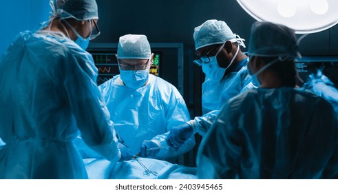 Team of medical doctors performs surgical operation in modern operating room using high-tech technology. Surgeons are working to save the patient in the hospital. Medicine, health and science. - Powered by Shutterstock