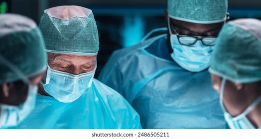 Team of medical doctors performs surgical operation in modern operating room using high-tech technology. Surgeons are working to save the patient in the hospital. Medicine, health and science. - Powered by Shutterstock