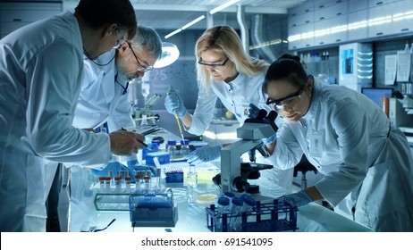 Team of Medical Research Scientists Collectively Working on a New Generation Experimental Drug Treatment. Laboratory Looks Busy, Bright and Modern.