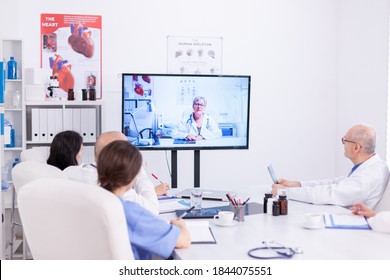 Team of medical staff during video conference with doctor in hospital meeting room. Medicine staff using internet during online meeting with expert doctor for expertise. - Shutterstock ID 1844075551