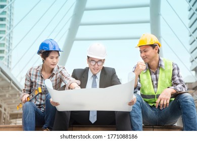 Team of middle asian man, woman engineer and architects working, meeting, discussing, designing, planning, measuring layout of building blueprints in construction site. Construction engineer architect