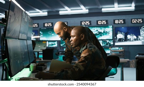 Team of military officers in command center look at intel folder files on enemy battle formation. Intelligence corps colleagues read mission case file to collect data on opponents strategy, camera B - Powered by Shutterstock