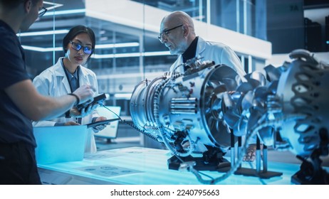 Team of Multicultural Engineers Use Testing Device and Tablet Computers, Analyze and Discuss How a Modern Electric Turbine Motor Works. High Tech Research Laboratory with Modern Equipment. - Powered by Shutterstock