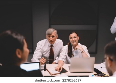 Team of multiethnic businesspeople in formal outfit with computers looking at camera and smiling while sharing ideas and working together on briefing - Shutterstock ID 2278262637