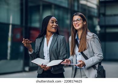 Team of multiracial successful business women on their way to the office talking about strategy. Diverse women walking outside with buildings in the background. Teamwork concept. Copy space. - Powered by Shutterstock