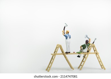 A team of painters on a scaffolding isolated on white background - Shutterstock ID 2114747081