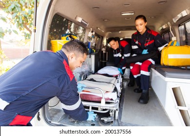 Team Paramedics Taking Stretcher Out Of An Ambulance