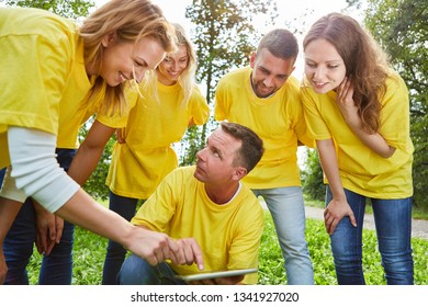 Team Planning Strategy With Tablet Computer At A Team Building Event