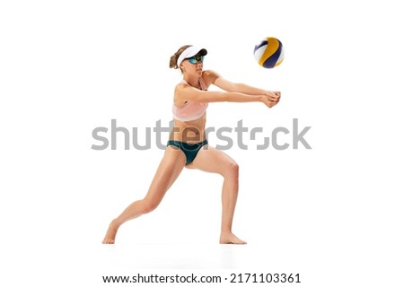 Team player. Studio shot of one fitness young woman, volleyball player in sports swimsuit playing isolated on white background. Sport, healthy lifestyle, team, fitness concept. Summer sports games
