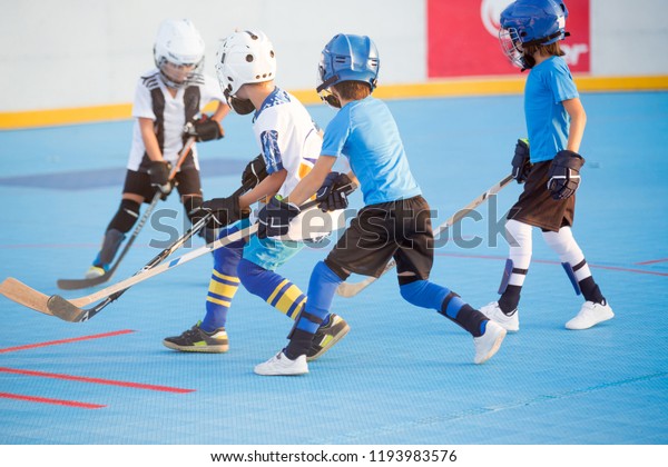 Team\
players having competitive hockey game\
outdoors