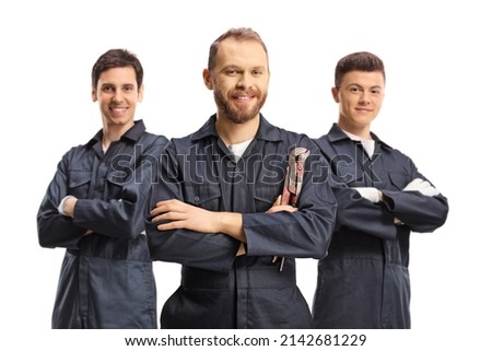 Team of plumbers in uniforms looking at camera isolated on white background
