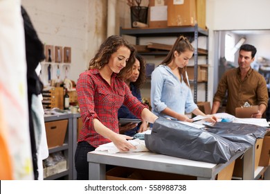 Team in a post room packing clothes orders for distribution - Powered by Shutterstock