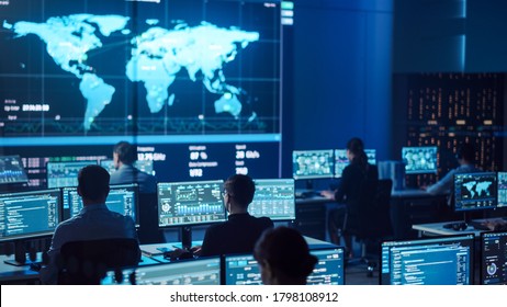 Team of Professional Computer Data Science Engineers Work on Desktops with Screens Showing Charts, Graphs, Infographics, Technical Neural Network Data and Statistics. Dark Control and Monitoring Room. - Shutterstock ID 1798108912