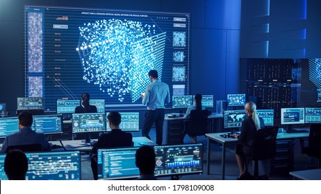 Team of Professional Computer Data Science Engineers Work on Desktops with Screens Showing Charts, Graphs, Infographics, Technical Neural Network Data and Statistics. Dark Control and Monitoring Room.