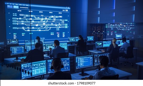 Team Of Professional Computer Data Science Engineers Work On Desktops With Screens Showing Charts, Graphs, Infographics, Technical Neural Data And Statistics. Low Key Control And Monitoring Room.