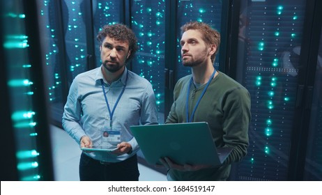 Team of professional data center engineers setting server hardware working on laptop coworking in digital server room. Webhosting. Technology concept. - Powered by Shutterstock