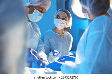 Team Of Professional Doctors Performing Operation In Surgery Room