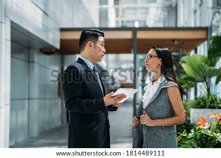 Team of professional employees discussing ideas on new project using digital tablet together stock photo