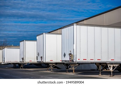 Team of professional freight commercial dry van semi trailers without industrial big rig semi trucks standing at row on business parking lot loading=