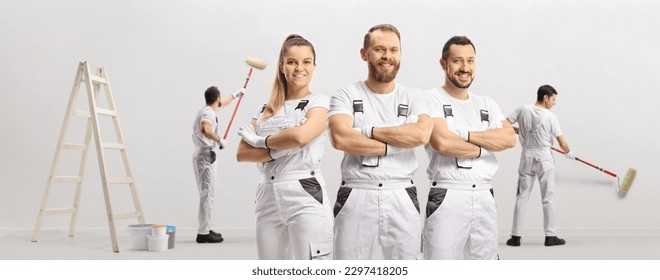 Team of professional painters painting a wall - Shutterstock ID 2297418205