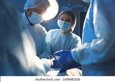Team of professional surgeons performing operation in clinic