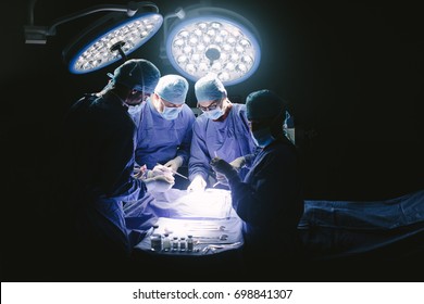 Team of professional surgeons performing surgery in operation room.  Group of surgeon at work in operation theater.
