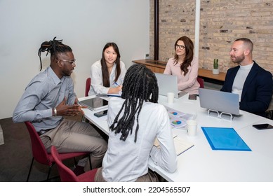 Team Of Professionals, Five Multi Ethnic Business People Negotiating In Boardroom, Discuss Project, Consider Contract Terms And Conditions, Solve Business. Formal Meeting Event Concept