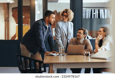 Team of professionals having a meeting in a digital marketing agency. Business people discussing a project in an office. Teamwork and collaboration in a creative workplace.