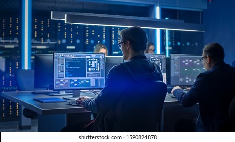 Team of IT Programers Working on Desktop Computers in Data Center Control Room. Young Professionals Writing on Sophisticated Programming Code Language