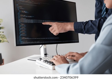 Team of programmer pointing to desktop computer with developing programming code, trying to solve the problem.