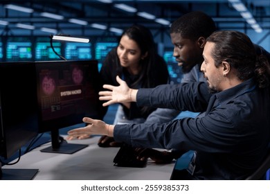 Team of programmers in server hub facility frightened by hacker passing firewall and stealing data. Multiracial colleagues panicking after seeing security breach notification on monitor in data center