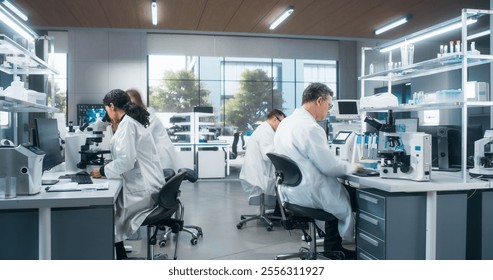 Team of Research Scientists Using Microscopes and Computers, Analyzing Test Trial Data of a New Generation Medical Drug. Diverse Men and Women Working in a Modern Bioengineering Laboratory