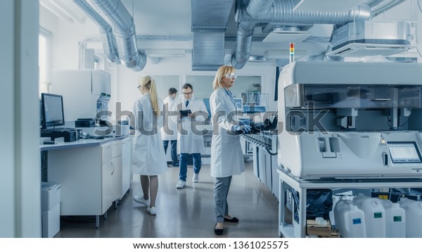 Team of Research Scientists\
Working On Computer, with Medical Equipment, Analyzing Blood and\
Genetic Material Samples with Special Machines in the Modern\
Laboratory.