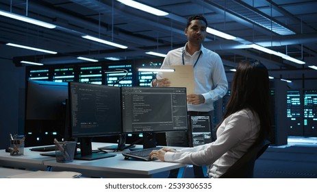 Team of researchers in data center monitoring security threats using PC, implementing cybersecurity measures. Teamworking colleagues ensuring compliance with regulations, camera B - Powered by Shutterstock