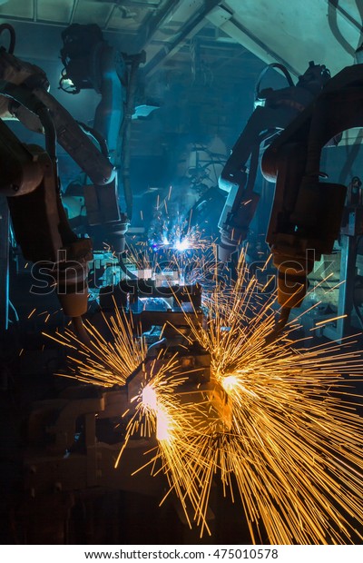 Team robots welding\
automotive part\
