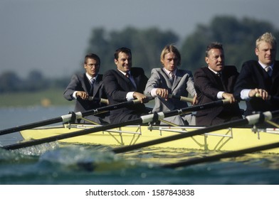 Team Of Rowers In Business Suits