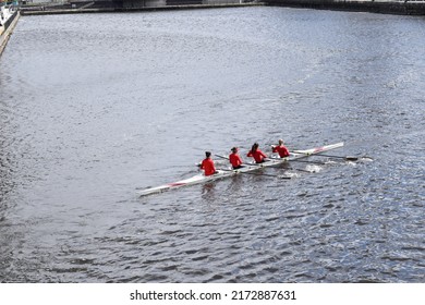 A Team Of Rowers Training On A Fast Flowing River. 