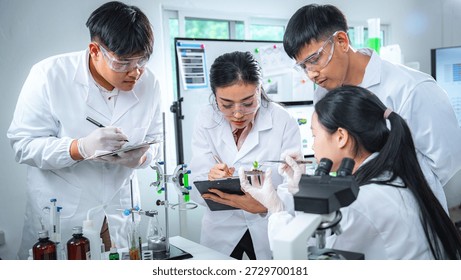 Team of scientists collaborating on algae and plant-based bioenergy research in laboratory, representing renewable energy testing clean technology innovation, sustainability, and ESG-focused corporate